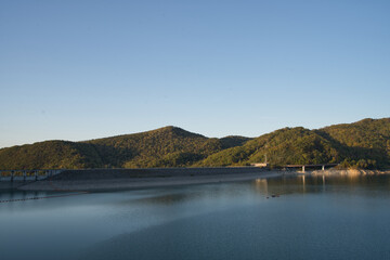 北海道旭川市の忠別湖にある忠別ダムの秋の紅葉と夕暮れ時の湖面と青空