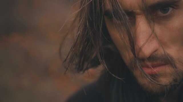 Autumn Portrait &ndash; Young, attractive European man with long hair in black coat, red rowan berries, close-up face, autumn rain, fresh, looking at camera, hair covering face, big eyes, long lashes 