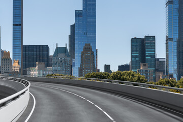 Obraz premium Curved road with modern skyscrapers in New York City skyline in the background.