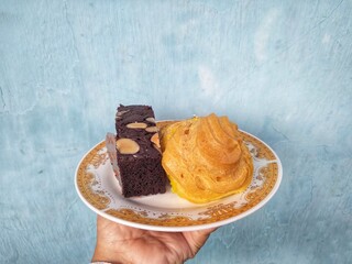 many cakes in one plate such as bronis chocolate cake, sus cake and rolled pineapple flavored cake