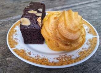 many cakes in one plate such as bronis chocolate cake, sus cake and rolled pineapple flavored cake