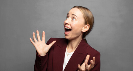 Fototapeta premium feeling happy, amazed, lucky and surprised, celebrating victory with both hands up in the air