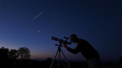 Amateur astronomer looking at the evening skies, observing planets, stars, Moon and other celestial...