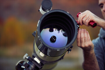 Amateur astronomer collimating astronomy telescope for sharper picture before observing stars,...