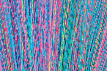 Colorful Wavy Threads Creating a Vibrant Background of Intertwined Textures in Bright Shades of Blue, Pink, Green, and Yellow for Creative Projects and Artistic Designs