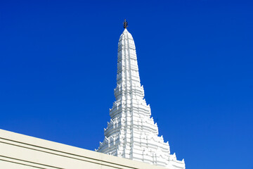 Majestic White Temple with Detailed Architecture Against a Clear Blue Sky, Showcasing Intricate Design and Spiritual Significance in a Serene Environment