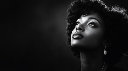 A woman with a beautiful afro hairstyle looks up at the light, her eyes filled with hope.