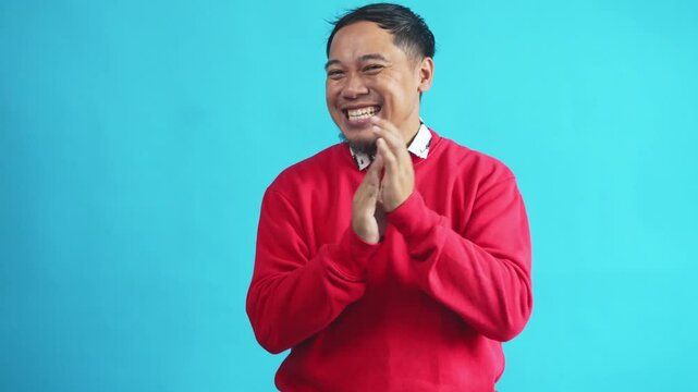 Happy Asian Man In Red Sweater Giving Surprise Gesture, Clapping Hands and Thumb Up At Camera