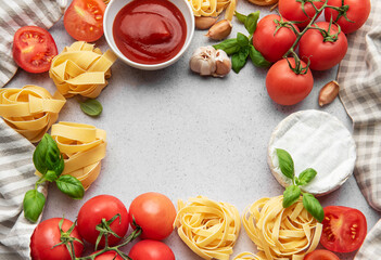 Italian food background featuring tomatoes, pasta, garlic, cheese, basil and tomato sauce creating a frame