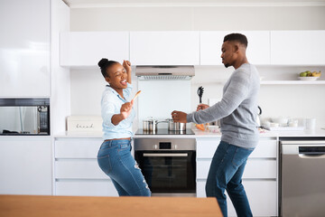 Black couple, dancing and home for love, energy and music for weekend rhythm in kitchen. Happy...