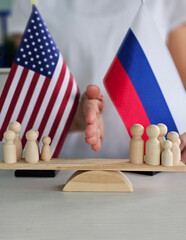 Diplomatic representation of US and Russia through wooden figures at a negotiation table during a...