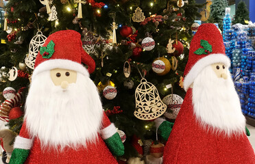 Two cute Santa Clauses near the Christmas tree.