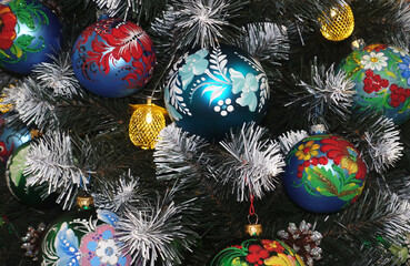 Christmas balls with beautiful hand painted flowers decorate the Christmas tree.