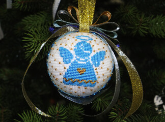 Christmas ball with Ukrainian style angel embroidery hanging on the tree  
