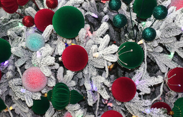 Christmas tree covered with snow and green and red balls.