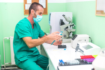 Veterinarian using micropipette filling test tubes for blood analysis