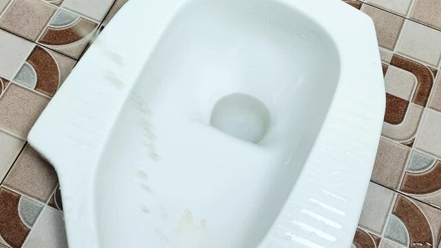 Urinating in the white squat toilet in the bathroom