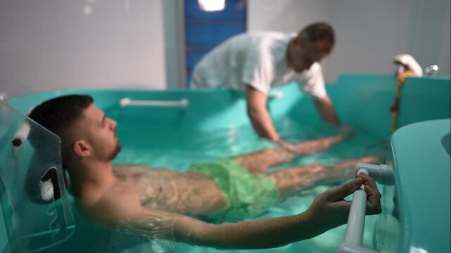 Close-up of a therapist performing hydrotherapy for leg and knee rehabilitation in a spa setting, gently supporting the patient's foot underwater. Concept of physical therapy and healing