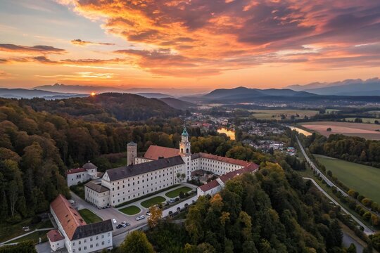 Aerial View of Augustiner Br&auml;u Kloster M&uuml;lln in Salzburg, Austria During a Breathtaking Sunset with Rich Colors Over Historic Architecture and Scenic Landscapes