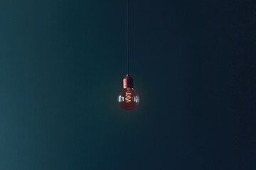 Minimalistic design of a hanging incandescent bulb in dark space