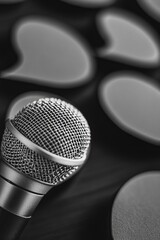 Microphone in front of a heart shaped paper cutout.