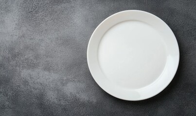 A clean, empty white plate on a textured dark gray surface, ready for delicious servings.