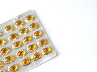 golden pills Medicine tablet capsules in blister pack on a white background. vitamins And Supplements, Concept health benefits, nutrition, omega 3 and 6, sun, pain relief and vitamin D