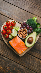 Heart shaped wooden board displays healthy food items emphasizing balanced diet Vertical Mobile Wallpaper
