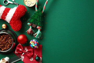 Festive pet accessories on a green background, including a striped pet bone, Christmas tree chew...