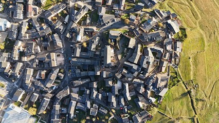 Circular mountain village and church with fields from above