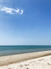 Obraz premium Serene beach with clear blue sky and calm ocean waves