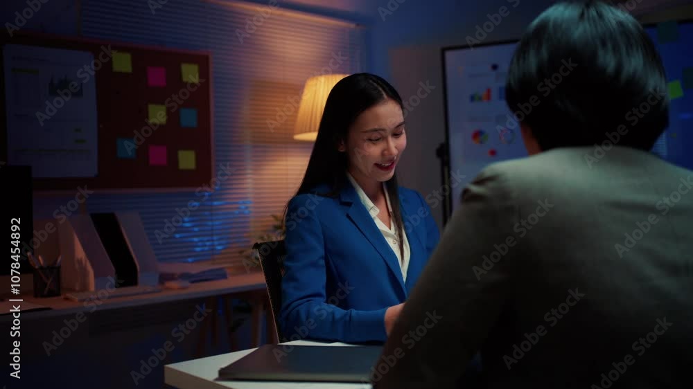 Poster asian businesswoman passionately discussing a project with a colleague in a modern office setting at