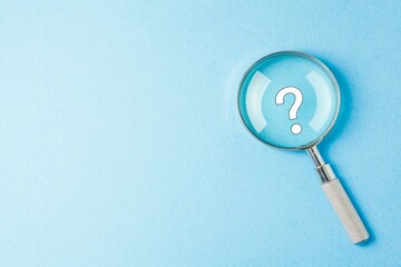 A magnifier focus on a questionmark icon at a clean colored background