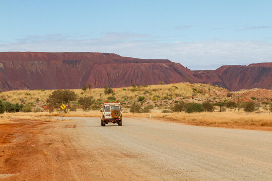 4WD vehicle driving on dirt road toward an iron ore mine