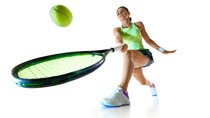 Low angle view of young woman tennis player in bright uniform stretches forward to hit ball against...