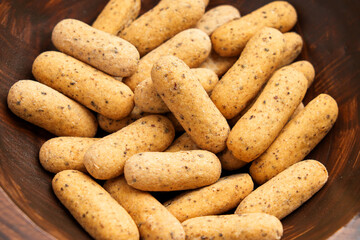 Crispy mini bread rolls (picos) top view in wooden bowl. Typical baked snack of Spanish Andalusian cuisine