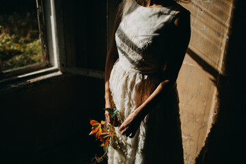 Hands Holding Leaves Against White Textured Dress