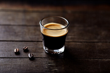 Coffee in glass cup on dark background. Close up. Copy space.