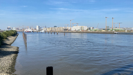 Fototapeta premium Urban Riverfront with Construction and Cruise Ship in View