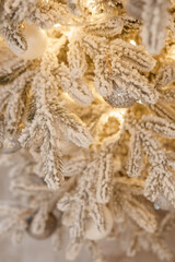 A Christmas tree sprinkled with artificial snow in the New Year's interior. Background for New Year wallpapers and postcards.
