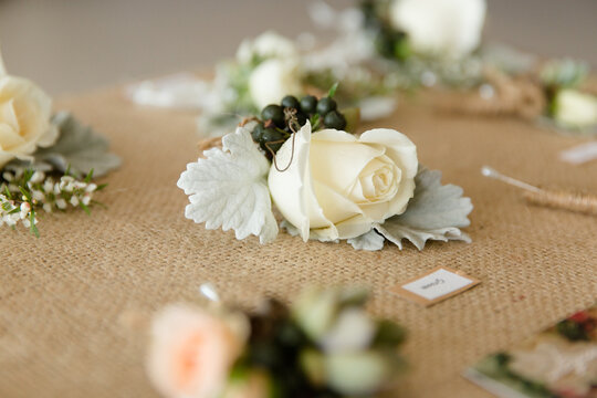boutonniere with roses and berries ready for a wedding