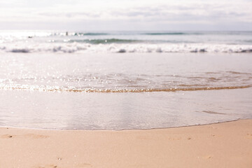 gentle waves rolling in at the beach with pastel colours