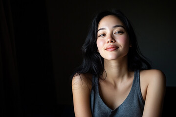 Naklejka premium Portrait of Asian woman with radiant, glowing skin peaceful expression. focusing on her natural beauty and luminous skin.