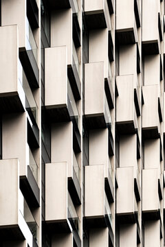 The image features a close-up perspective of a building&rsquo;s exterior, focusing on the geometric arrangement of balconies creating a pattern of repetition and modern design  in London UK