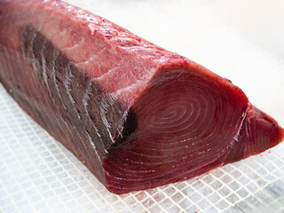 Fresh raw tuna loin on white background in grocery

