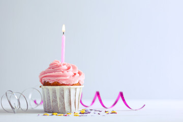 A deliciously appealing and beautifully decorated Pink Frosted Birthday Cupcake topped with a Candle