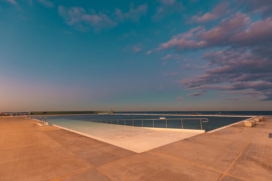 The Newcastle Ocean Baths at dusk with pink and purple fairy floss sky