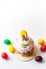 Board with delicious Easter cake and eggs on white background . Close-up of easter eggs with flowers and cake over white background