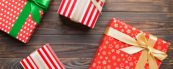 Fototapeta premium A lot of Christmas gift boxes in colored paper decorated on table, Top view close up. Many present New Year gift