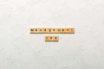 management fee word written on wood block. management fee text on cement table for your desing,...
